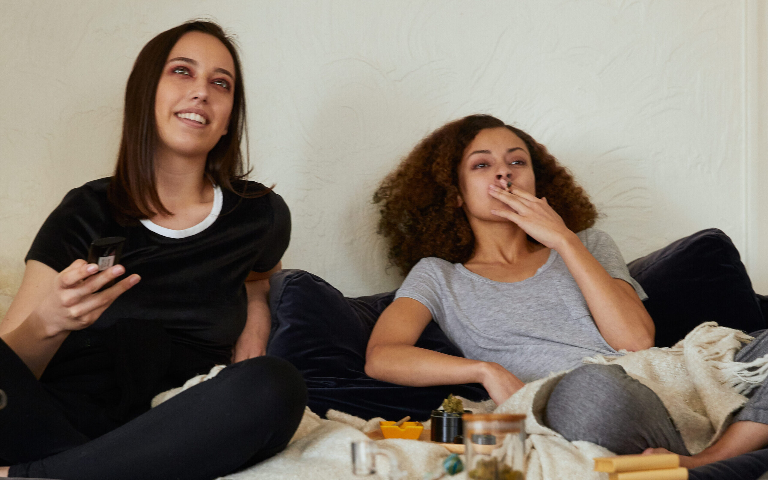 Two women watching tv while getting high