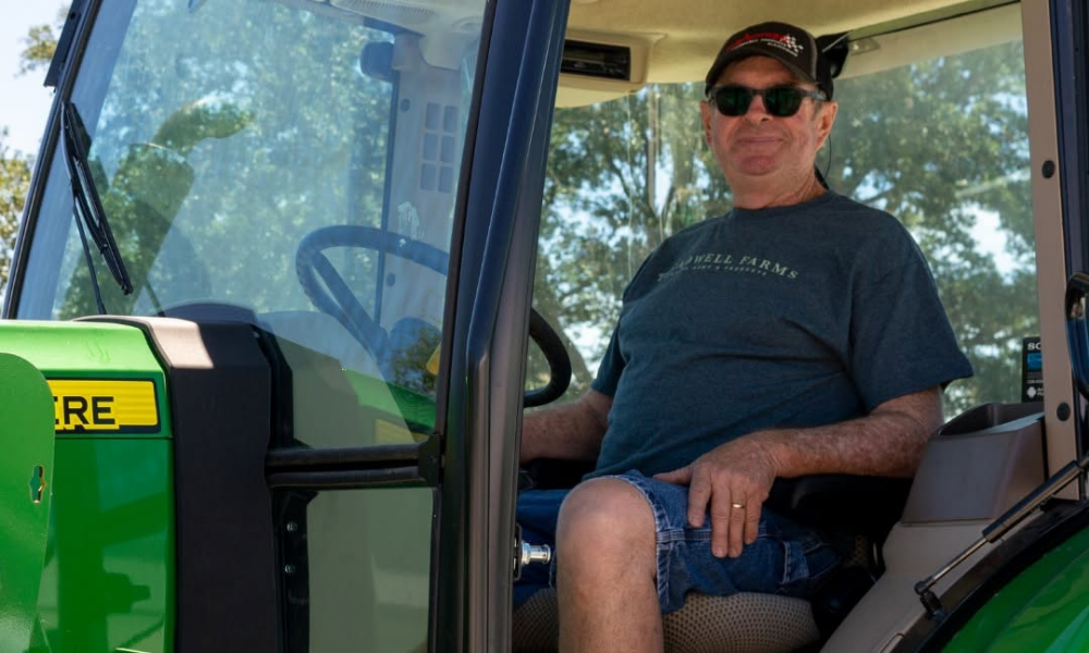 A Treadwell Farms farmer seated on a tractor